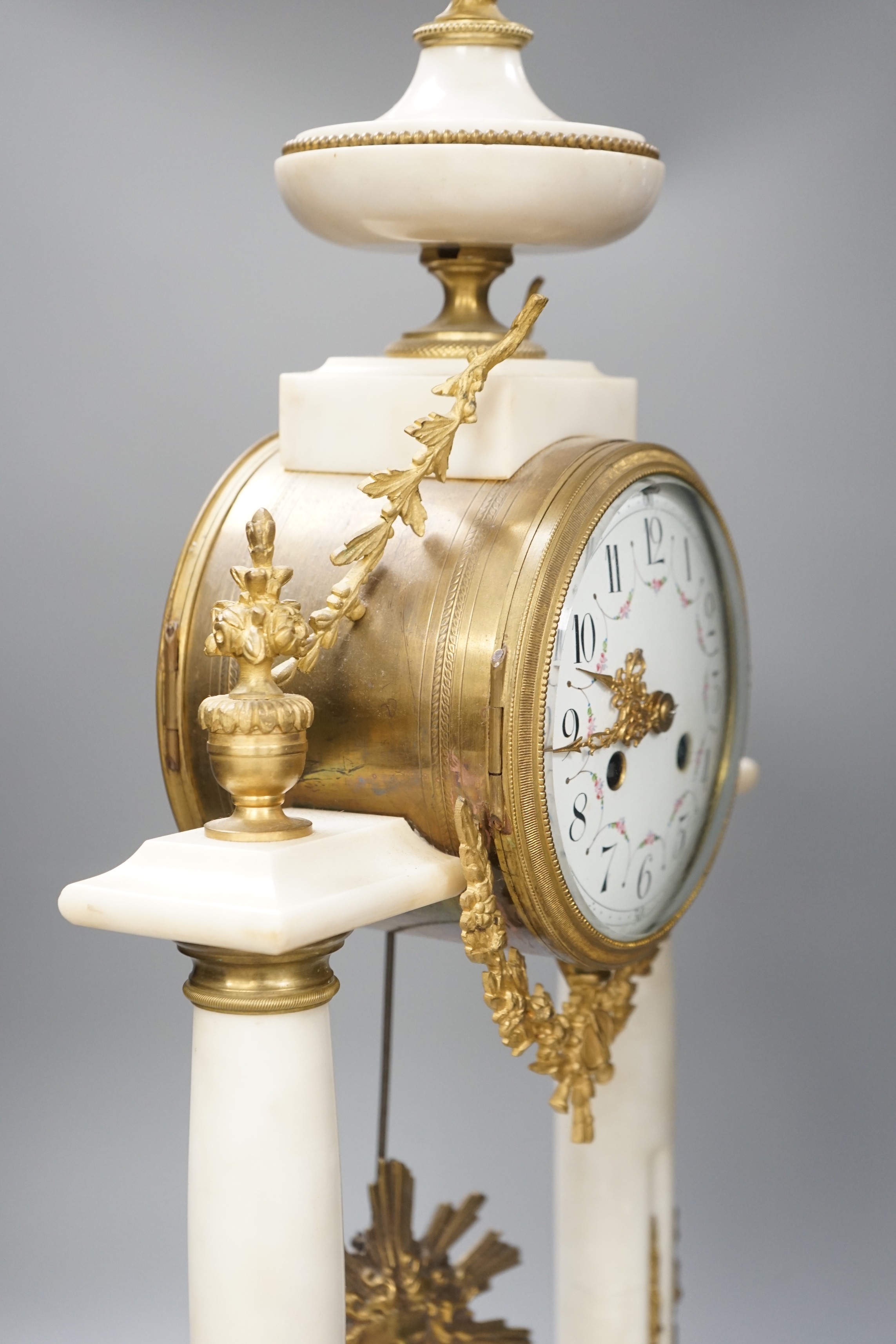 A large French white marble portico clock with ormolu decoration and sunburst pendulum, 59.5cm tall